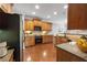 Well-lit kitchen with wood cabinets and black appliances at 5317 Concordia Pl, Mableton, GA 30126