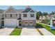 Two-story townhome with gray and beige siding, a two-car garage, and landscaping at 150 Switcher Ct, Union City, GA 30291