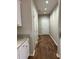 Hallway with wood floors leading to a door, featuring white cabinets and granite countertops at 1250 Adamson Rd, Bowdon, GA 30108