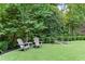 Relaxing backyard with two Adirondack chairs and a small table, perfect for enjoying the peaceful wooded surroundings at 2908 Mabry Ne Ln, Brookhaven, GA 30319