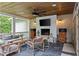 Cozy covered patio with fireplace, wood ceiling, and comfortable seating area at 2908 Mabry Ne Ln, Brookhaven, GA 30319