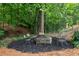 Cozy firepit area with a stone firepit and seating surrounded by lush trees, ideal for outdoor gatherings at 2908 Mabry Ne Ln, Brookhaven, GA 30319