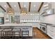 Bright kitchen features white cabinets, marble counters, a stainless hood, dark floors and wood beam details at 2908 Mabry Ne Ln, Brookhaven, GA 30319