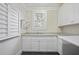 Laundry room features white cabinets, granite countertops, and natural light from window at 2908 Mabry Ne Ln, Brookhaven, GA 30319