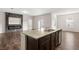 Open living room with a granite countertop kitchen island, hardwood floors, and a modern fireplace at 4444 Kendrick Cir, Loganville, GA 30052