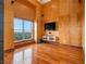 Living room with hardwood floors, wood paneling, and a large window with scenic views at 3334 Peachtree Ne Rd # 1707, Atlanta, GA 30326