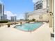 An outdoor community pool features lounge chairs, manicured plants, and city skyline views at 3334 Peachtree Ne Rd # 1707, Atlanta, GA 30326