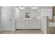 Double vanity bathroom with beige tile floor and white cabinets at 7470 Flintlock Way, Alpharetta, GA 30005