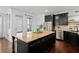 Kitchen island with granite countertop and dark cabinetry at 7470 Flintlock Way, Alpharetta, GA 30005