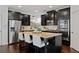 Modern kitchen with dark cabinetry, granite island, and stainless steel appliances at 7470 Flintlock Way, Alpharetta, GA 30005