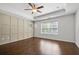 Bright main bedroom with hardwood floors, ceiling fan, and large window at 7470 Flintlock Way, Alpharetta, GA 30005