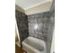 Under-construction basement bathroom with tiled walls and soaking tub at 5544 Whispering Swan Ct, Douglasville, GA 30135