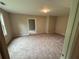 A carpeted bedroom featuring tan walls, a light and a large window providing natural light at 5544 Whispering Swan Ct, Douglasville, GA 30135