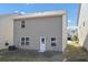 The backyard features a door leading into the house, an air conditioning unit, and green grass at 10922 Wheeler Trce, Hampton, GA 30228