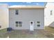 The backyard features a door leading into the house, an air conditioning unit, and green grass at 10922 Wheeler Trce, Hampton, GA 30228