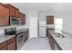 A modern kitchen featuring an island, stainless steel appliances, and wood cabinets at 10922 Wheeler Trce, Hampton, GA 30228