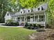 White two-story house with a large front porch and landscaping at 2100 Kings Valley Dr, Lawrenceville, GA 30043