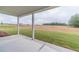 Covered patio with a view of the large grassy backyard and fencing at 63 Youth Jersey Rd, Covington, GA 30014