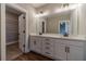 Bathroom featuring dual sinks, white cabinets, and a large mirror with modern lighting at 63 Youth Jersey Rd, Covington, GA 30014