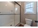 Modern bathroom with tiled shower, glass enclosure, and a window for natural light at 63 Youth Jersey Rd, Covington, GA 30014