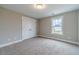 Bedroom features neutral walls, plush carpeting, and natural light from a nearby window at 63 Youth Jersey Rd, Covington, GA 30014