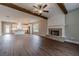 Open-concept living room with wood floors, fireplace, and exposed wood beam ceilings at 63 Youth Jersey Rd, Covington, GA 30014