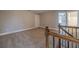 Bright loft featuring neutral walls, plush carpeting, and a stairway with wood and iron railings at 63 Youth Jersey Rd, Covington, GA 30014
