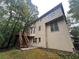 Tan house exterior with wooden deck and stairs, surrounded by lush green trees at 1824 Thornhill Se Pass, Conyers, GA 30013