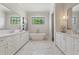 Luxurious bathroom with dual vanities, a standalone tub, and marble floors at 11 Brownson Ct, Acworth, GA 30101