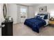 Spacious bedroom with blue bedding, window, and neutral walls at 6098 Zephyr Ln, Mableton, GA 30126