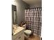 Bathroom with a sink, toilet, and shower featuring a modern designed shower curtain at 989 Park Knoll Ct, Lawrenceville, GA 30043