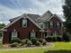 Traditional brick two-story home with dark shutters, manicured landscaping, and a curved walkway at 989 Park Knoll Ct, Lawrenceville, GA 30043