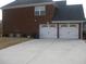 Attached two-car garage with a wide concrete driveway and brick exterior at 989 Park Knoll Ct, Lawrenceville, GA 30043