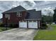 Home featuring an attached two-car garage, basketball hoop and a large driveway for parking at 989 Park Knoll Ct, Lawrenceville, GA 30043
