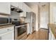 Efficient kitchen with granite countertops and stainless steel appliances, including a microwave, oven, and refrigerator at 5100 Windsor Forrest Ln, Atlanta, GA 30349