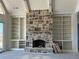 Living room features a stone fireplace flanked by built-in shelving, offering a cozy and organized space at 6110 Harvest Way, Cumming, GA 30028