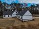 Aerial view of a modern farmhouse with detached garage and fenced yard at 2259 County Line Rd, Acworth, GA 30101