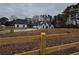 Farmhouse with wooden fence, showcasing its white siding and stone base at 2259 County Line Rd, Acworth, GA 30101