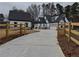 Two-story farmhouse with gray roof, white siding, stone accents, and long driveway at 2259 County Line Rd, Acworth, GA 30101