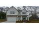Charming two-story home featuring a brick facade, white siding, and a well-manicured front lawn at 6055 Spring Way, Stonecrest, GA 30038
