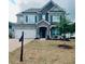 Two-story home with a stone and gray exterior, a two-car garage, and manicured lawn at 7665 Easton Valley Ln, Cumming, GA 30028