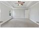 Spacious main bedroom with neutral carpet, tray ceilings, ceiling fan and ample natural light at 6061 Spring Way, Stonecrest, GA 30038