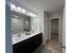 Bathroom with dual sink vanity, large mirror, shower, and storage closet at 3290 Forest Green Dr, Douglasville, GA 30135