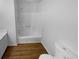 Bathroom with a clean white shower, tub, and wood look flooring at 320 Rebecca Lake Way, Fairburn, GA 30213