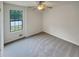 Bright bedroom featuring a ceiling fan, large window, and neutral carpet at 320 Rebecca Lake Way, Fairburn, GA 30213
