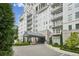 Exterior front entrance of white condominium building with awning and manicured landscaping at 2500 Peachtree Nw Rd # 405S, Atlanta, GA 30305