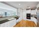 Contemporary kitchen featuring granite countertops, white cabinetry, stainless appliances, and hardwood flooring at 2500 Peachtree Nw Rd # 405S, Atlanta, GA 30305