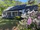 Charming single-story home featuring a screened porch and lush landscaping with vibrant flowers at 3970 Norman Rd, Stone Mountain, GA 30083