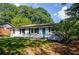 Charming one-story home with a well-manicured lawn, blue door, and a freshly painted white brick facade at 123 Arnold Pl, Jonesboro, GA 30236