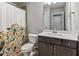 Charming bathroom featuring a vibrant shower curtain and vanity with storage at 1995 Woodmont Dr, Douglasville, GA 30135